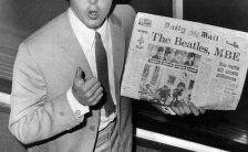 Paul McCartney with the Daily Mail newspaper bearing a headline about The Beatles' MBEs, 11 June 1965